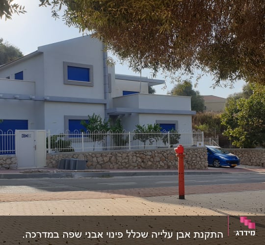 בית עם חלונות כחולים ועצים מסביב